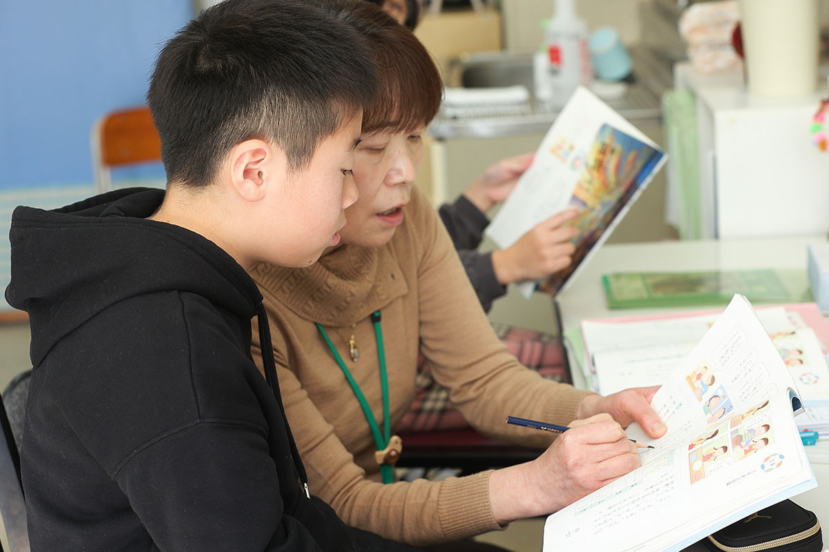 国語の教科書に細かなチェックを書き加える早坂氏