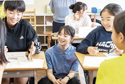 机を囲んで語り合う中学生のみなさんと久米絵美里さん