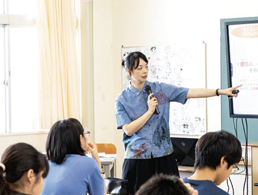 スライドを指しながら話す久米絵美里さんと中学生のみなさん