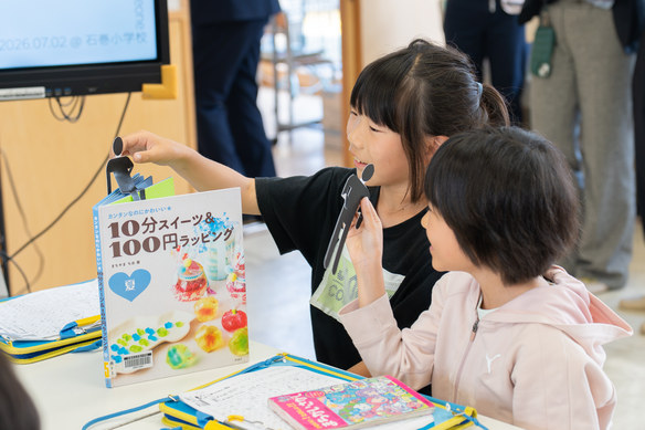 本の上に立てたピクトグラムを動かしながら相談する子どもたち