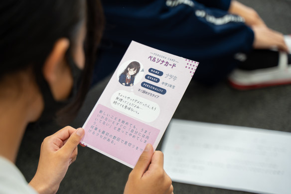 架空の人物の悩みが書かれたペルソナカードを手に取る生徒