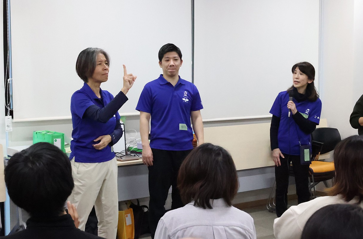 手話で保護者と語り合う物井明子さん、久保沢寛さん、解説する河﨑佳子さん（左から）