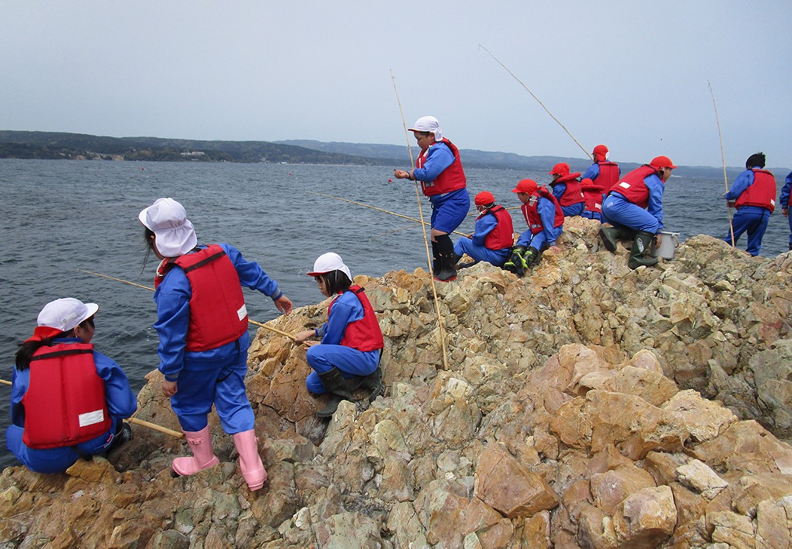 全校で里海遠足。岩場で釣りをしながら海の楽しさと厳しさを学ぶ